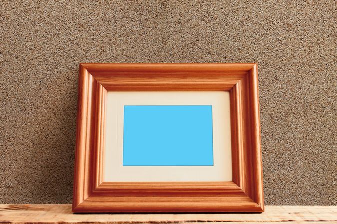 Rectangular wooden picture frame leaning against wall mockup
