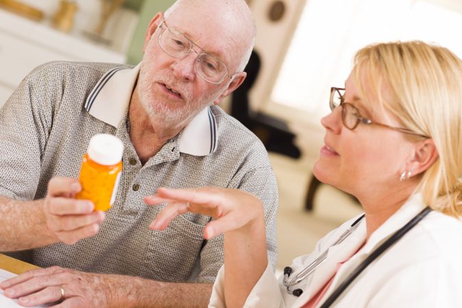 Doctor or Nurse Explaining Prescription Medicine to Older Man