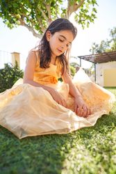 Girl sitting on grassy lawn and looking down