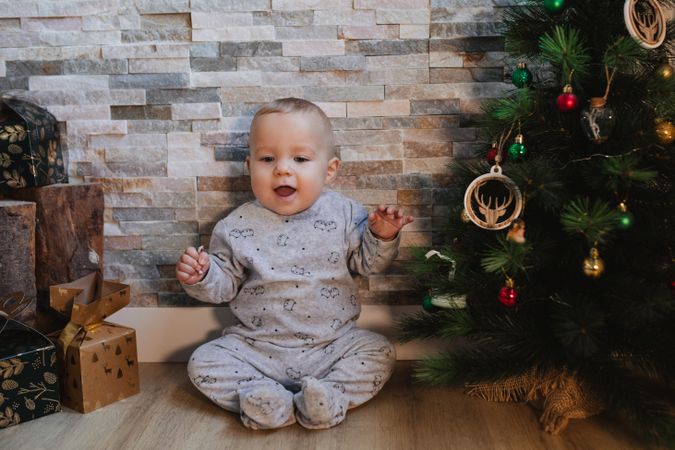 Cute baby playing with Christmas tree baubles