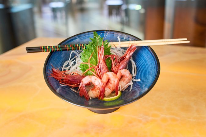 Tasty prawns on plate with chopsticks