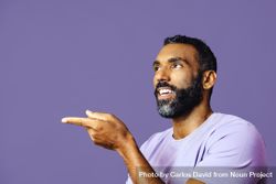 Side view of male talking in purple t-shirt while gesturing to the side, copy space bGy6Y5
