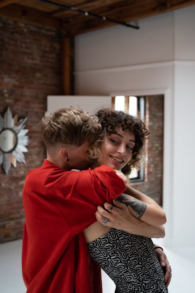 Woman with short hair buries her face in her girlfriend’s neck