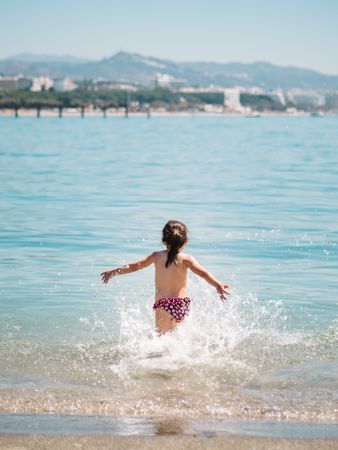 Cheerful girl having fun in warm sea