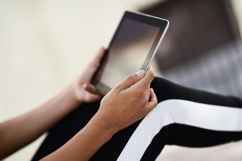 Digital tablet being held by woman on her knees