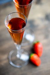 Pink champagne in flutes with strawberry garnish