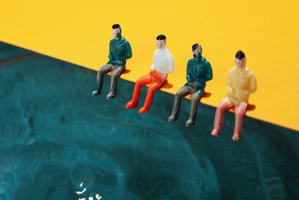 Four toy figures sitting on edge of pool