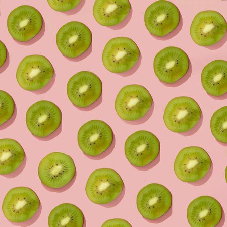 Fresh green kiwi pattern on a pink background