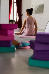 Woman sitting among sports equipment in studio