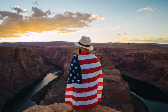 Anonymous male with USA flag near canyon