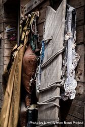 Close up of fishing clothes and board resting on wooden building 0K6NNb