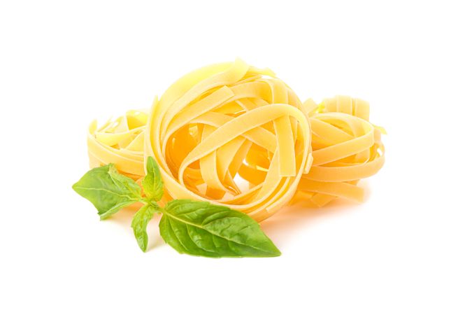 Pasta isolated on light background, closeup. Dry raw whole pasta