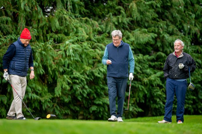 Mature male friends enjoying golf course