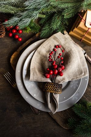Top view of holly berries on xmas table setting on wooden table