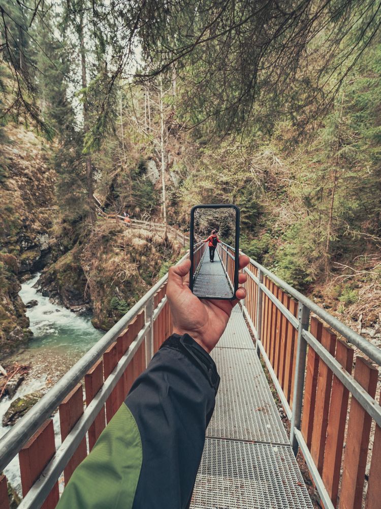 Tourist taking photo while walking on footpath