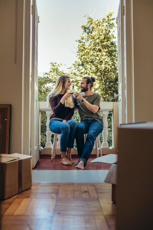 Couple enjoying wine sitting in the balcony of their home