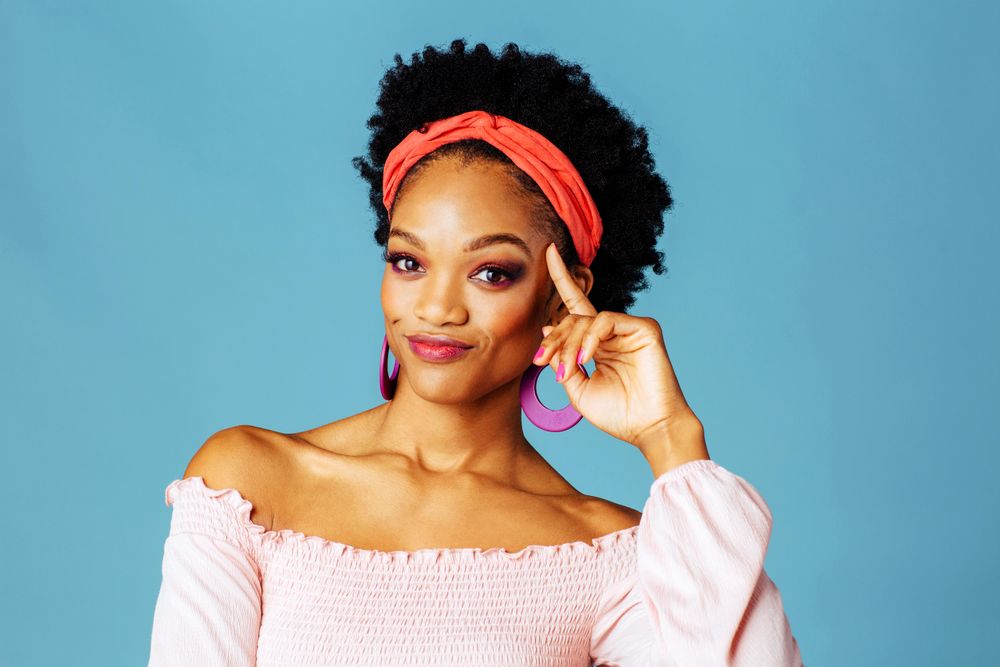 Studio shoot of curious Black woman with hand to her temple