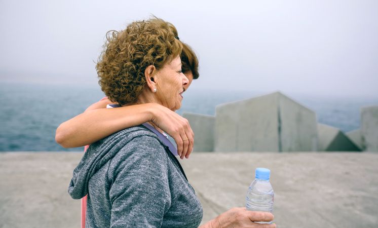 Two women walking by sea pier