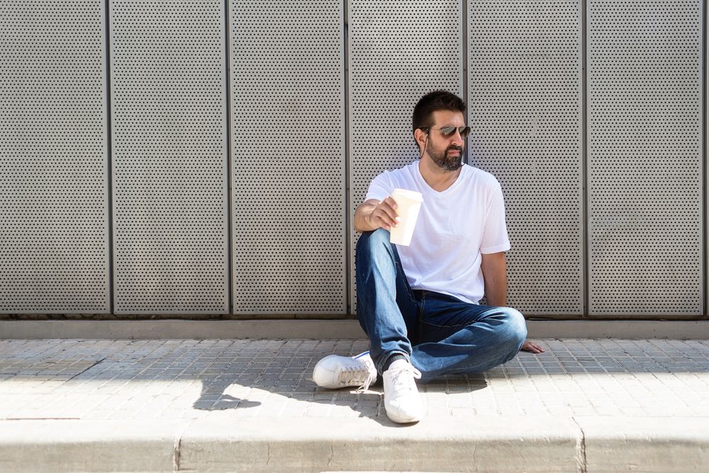 Latino man sitting outside with coffee