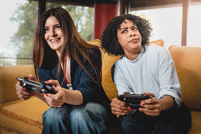 Playful young women having fun playing video games