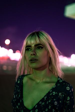 woman looking at camera against vibrant sky at dusk