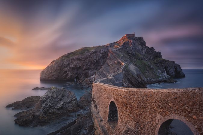 Lonesome rocky island with chapel and stone bridge
