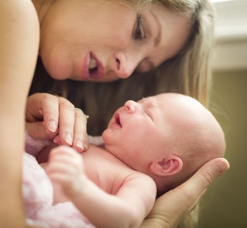 Young Mother Holding Her Brand New Newborn Baby Girl