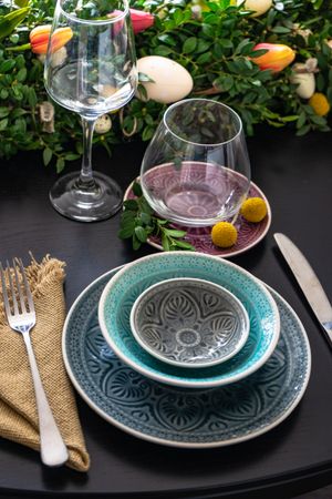 Easter table setting with patterned plates on table with floral centerpiece