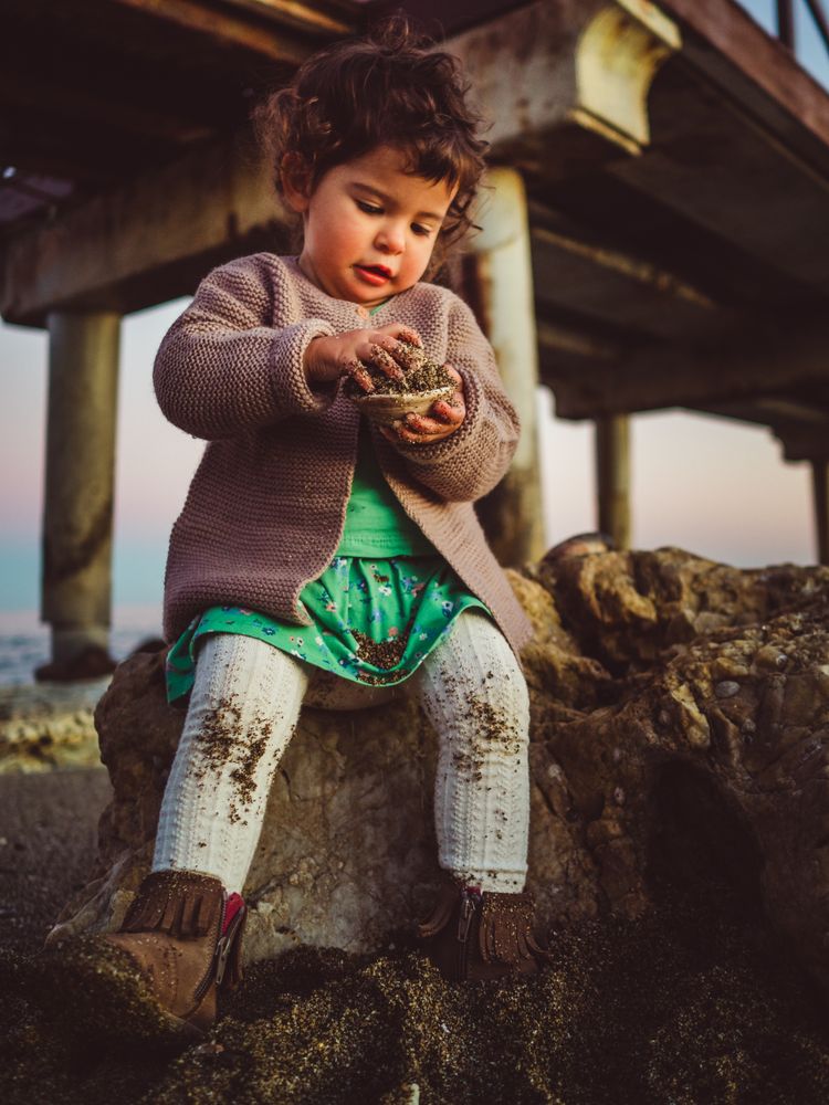 small girl playing with seashell