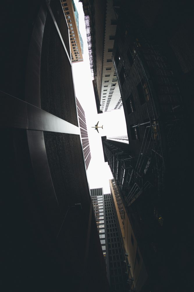 Bottom view photo of airplane passing over buildings