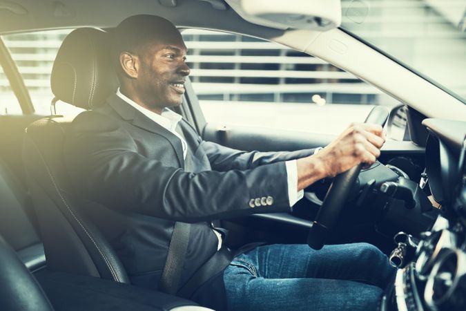 Man in business casual attire driving a vehicle