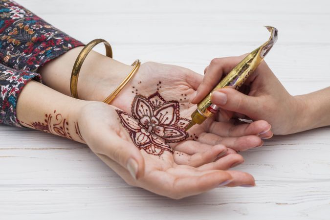 Woman putting henna on client’s hands