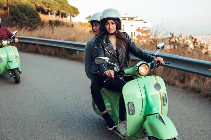 Young people riding motorcycles on city road