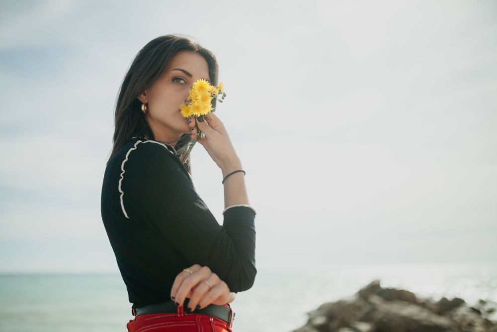 woman with flowers near to beach