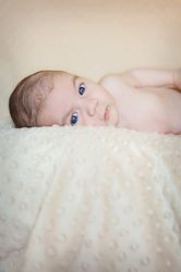 Portrait of newborn baby lying down over a blanket