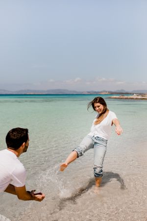 Cheerful lovers having fun on tropical coastline