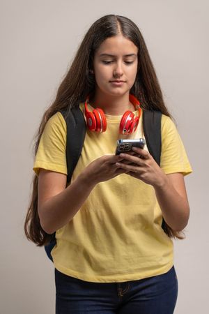 A young student using her smartphone, texting or Browse social media.