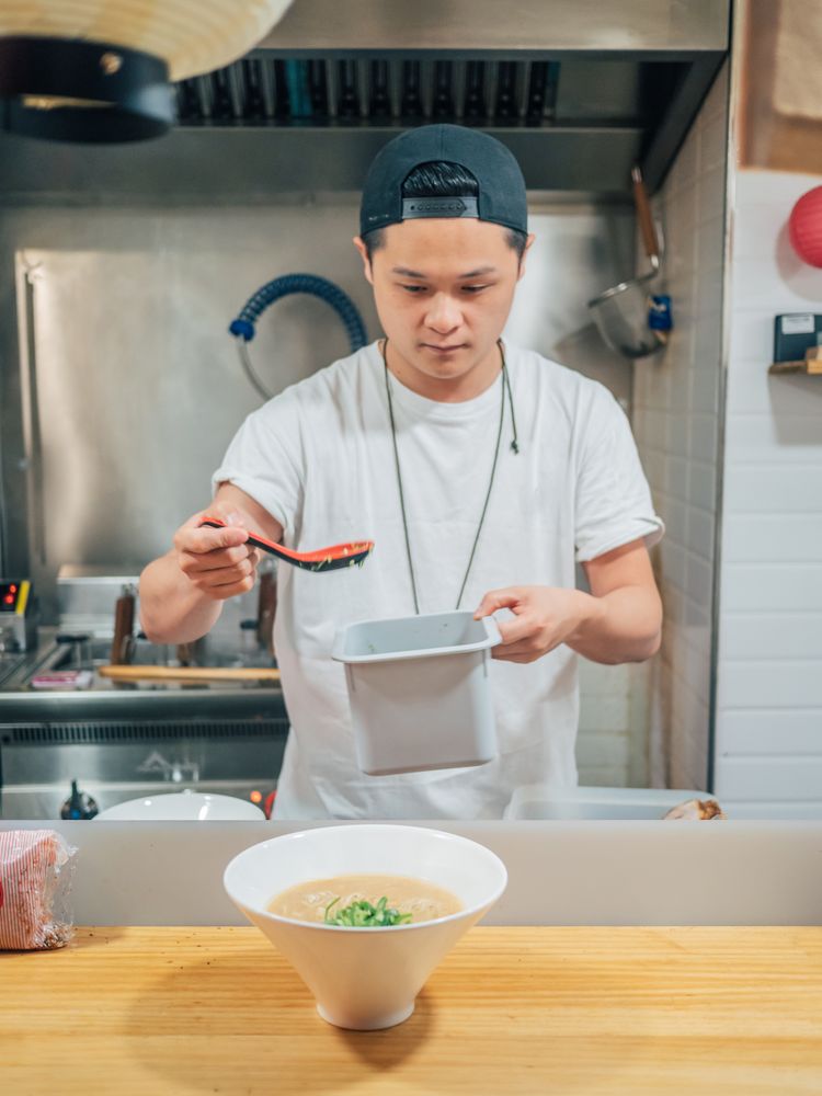 Young cook serving bowl with delicious ramen