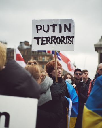 London, England, United Kingdom - March 5 2022: Man in group of people with “Putin Terrorist” sign