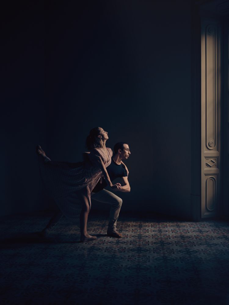 Couple dancing ballet in dark room