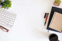 Office supplies with work space computer, pen, notepad paper, plants decorate and cup coffee