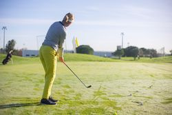 Back view of blonde woman playing golf