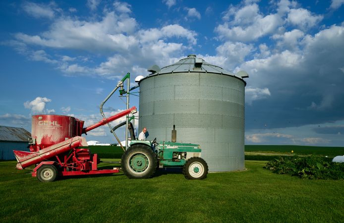 Dean Folkmann's operates a tractor, Benton County, near Newhall, Iowa