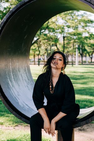 Young female relaxing on wooden round bench