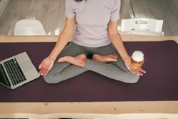 Unrecognizable female meditating with beer near laptop