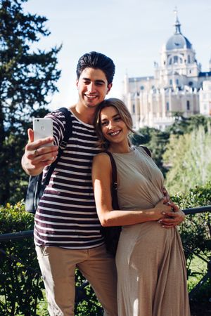 Happy young couple taking selfie in park