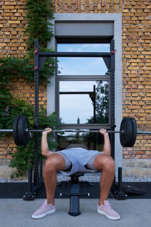 Man lifting barbell on street