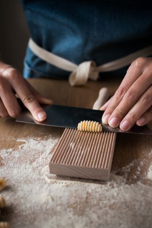 Crop woman making gnocchetti pasta