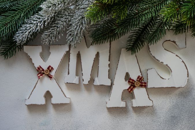 XMAS spelled in wooden letters with Christmas pine