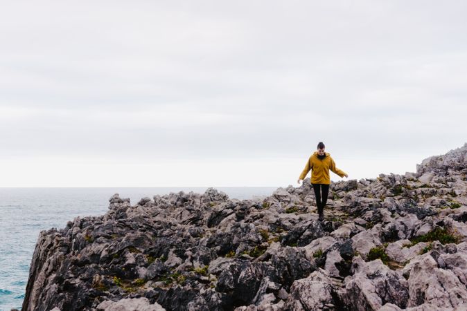 Traveler in solitude walking on rocky shore
